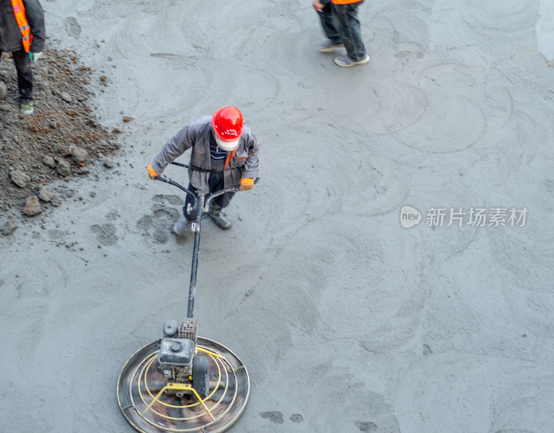 建筑工地上，工人正使用路面抹平机平整路面