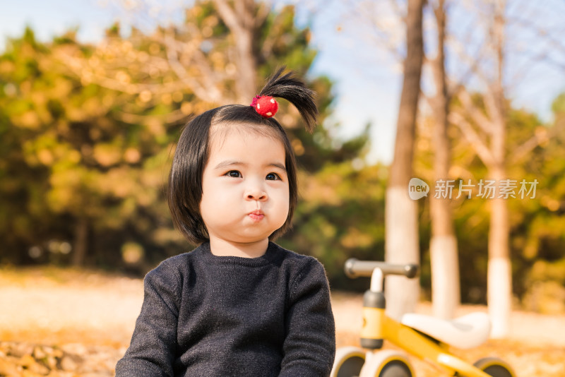 深秋坐在公园落满黄叶的草地上的女孩特写