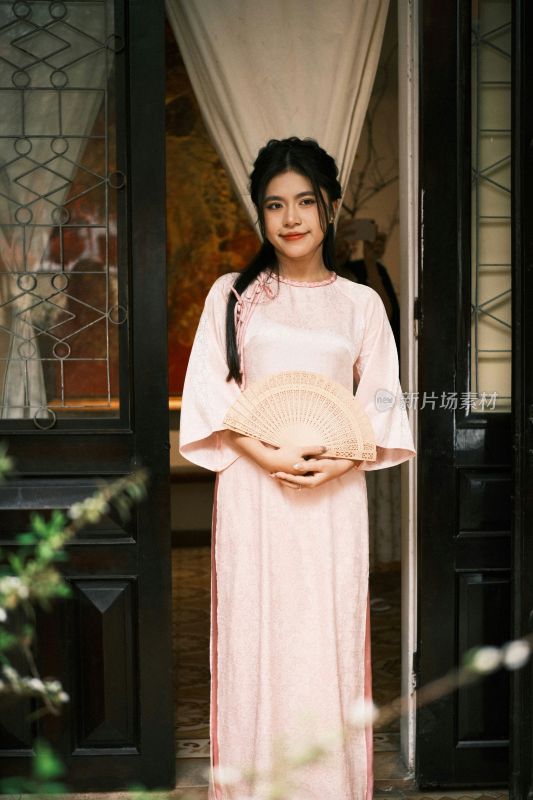 身着传统服饰女子手持折扇