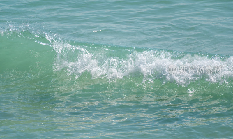 海南三亚阳光下绿松石海浪浪花冲浪
