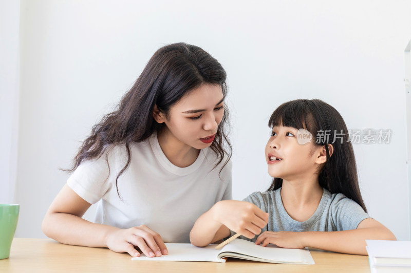 一名中国妈妈在辅导女儿写作业