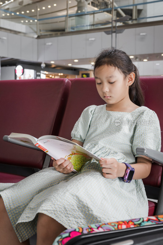 在机场候机厅等待登机看书的中国女孩