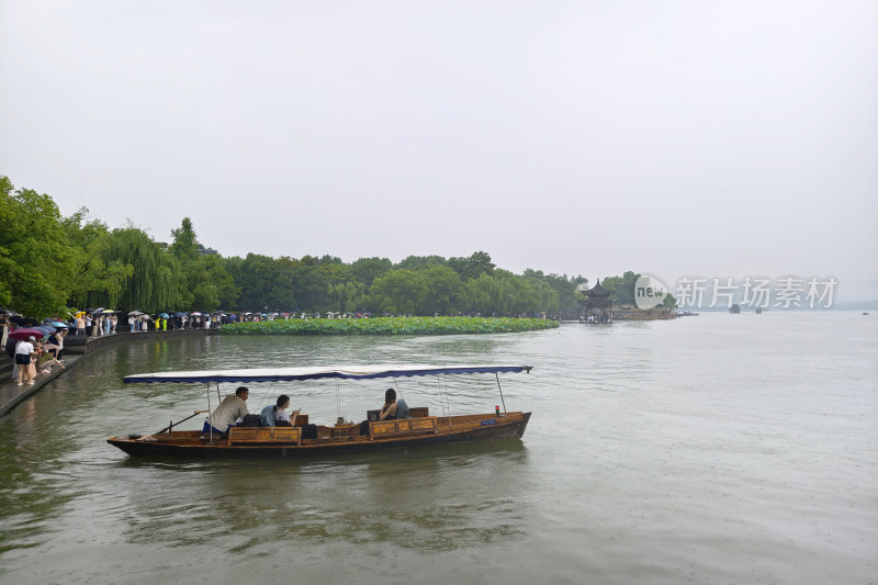 西湖边小船悠悠前行游客赏景