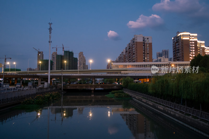 城市暮色中的河流与高架桥