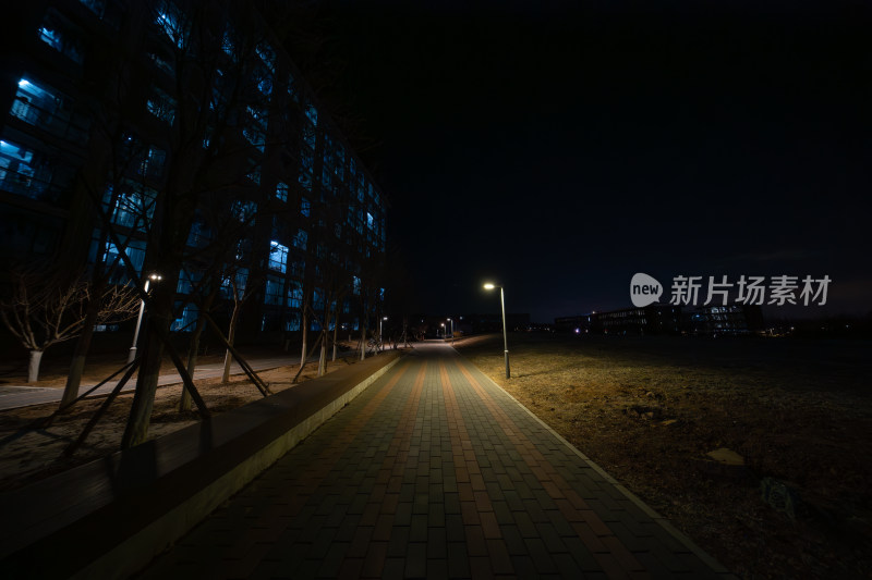 夜晚城市中亮灯建筑旁的步道