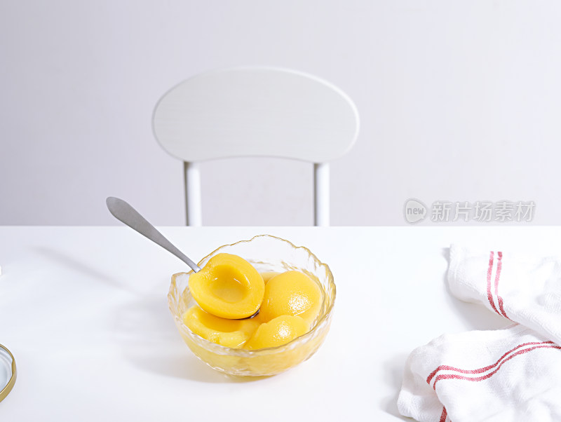 白色桌面上放着的美食黄桃罐头