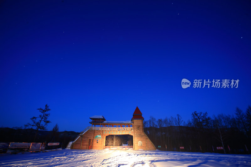 雪后景区木头做成的大门门楼夜景
