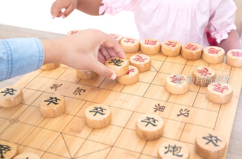 小女孩在和妈妈下中国象棋