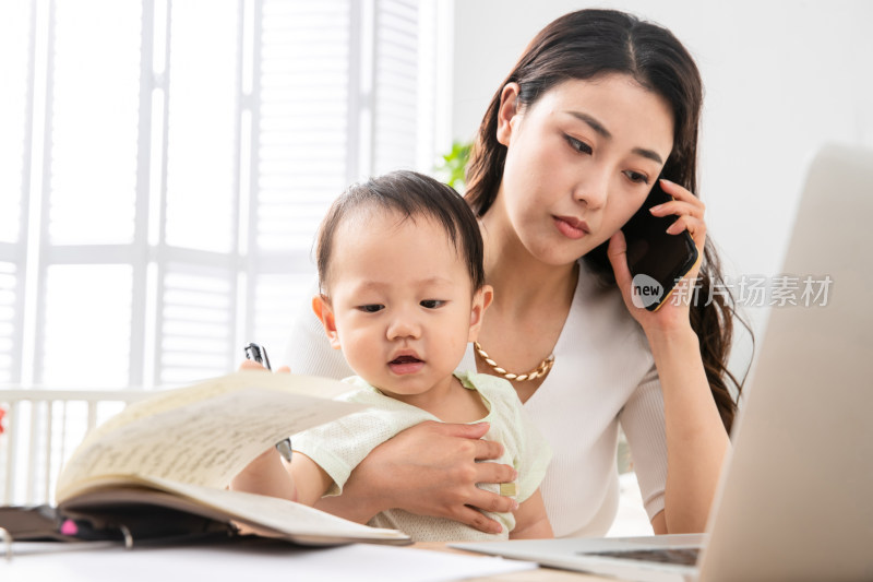 年轻妈妈带着宝宝看电脑