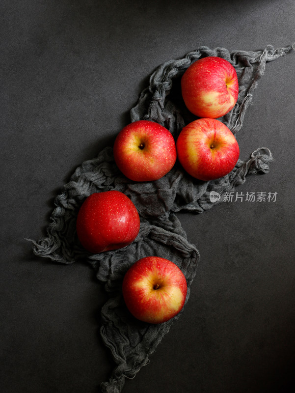 黑色桌面上摆放着一堆新鲜水果苹果