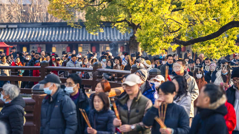 古建前人群手持香烛聚集场面