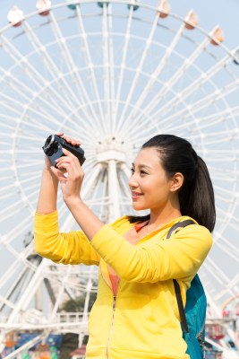 年轻女人手拿DV在游乐园