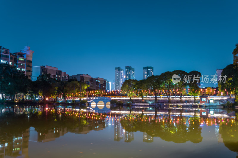 夜晚城市公园湖面倒映的璀璨灯光