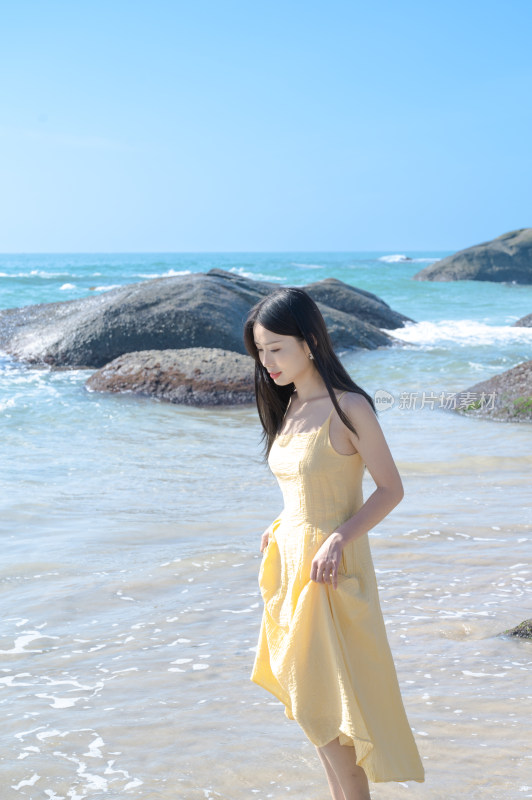 女子海边漫步，黄色连衣裙，晴空万里