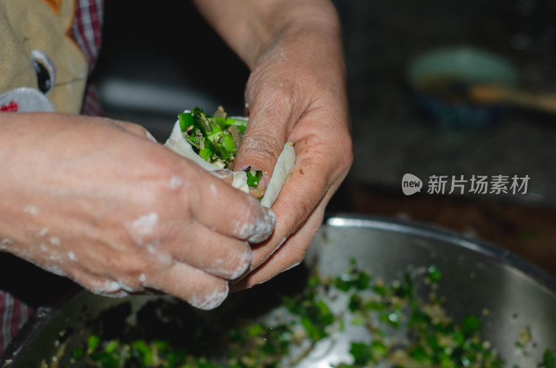 包包子，将馅料捏进包子皮里