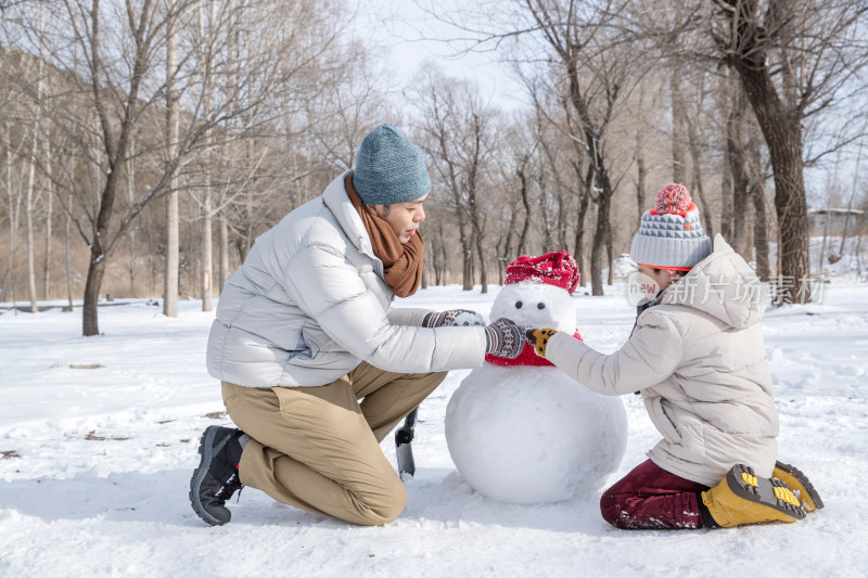 爸爸和孩子推雪人