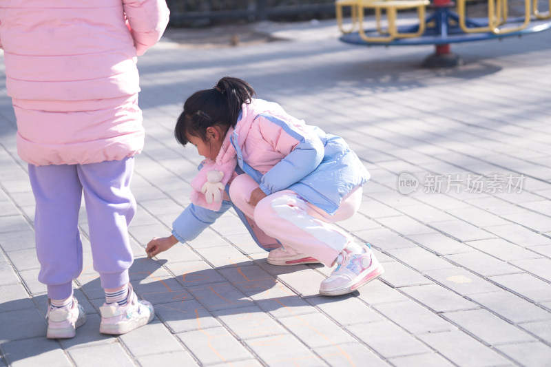 小女孩在地上画画