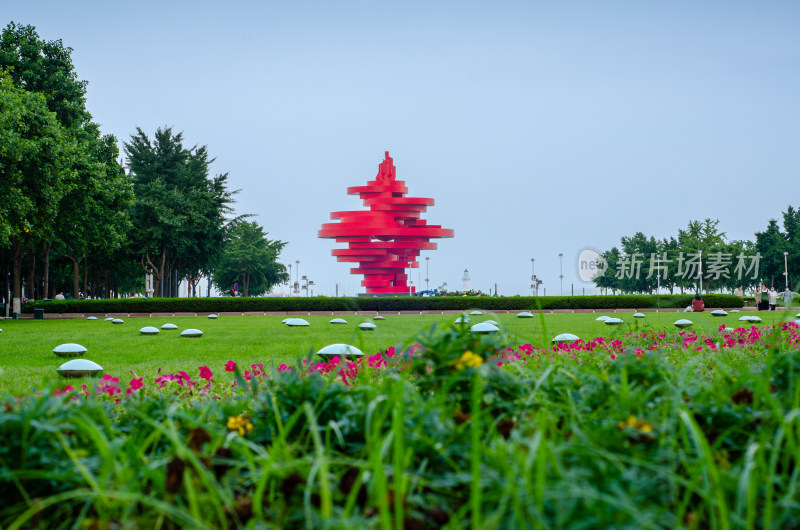 青岛五四广场绿地花丛中红色雕塑的城市风光