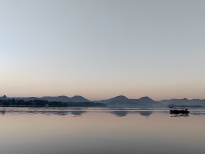 平静湖面上的小船与远处山峦的美景