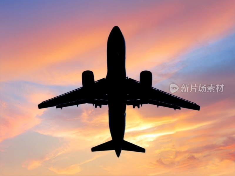 晚霞中飞行的飞机剪影