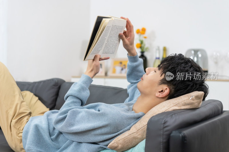 快乐的年轻男子在家看书
