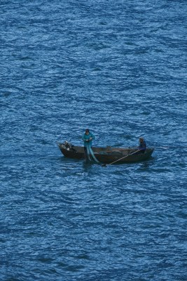 海上小船渔民撒网捕鱼