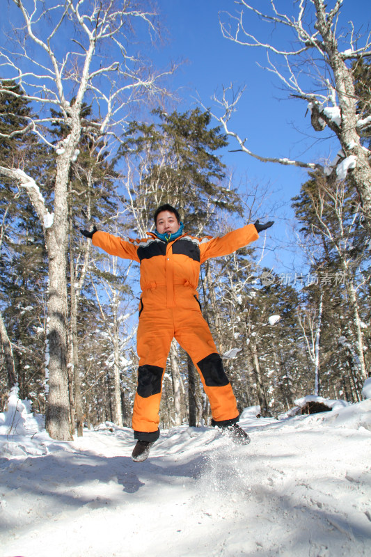 男子雪地林间跳跃
