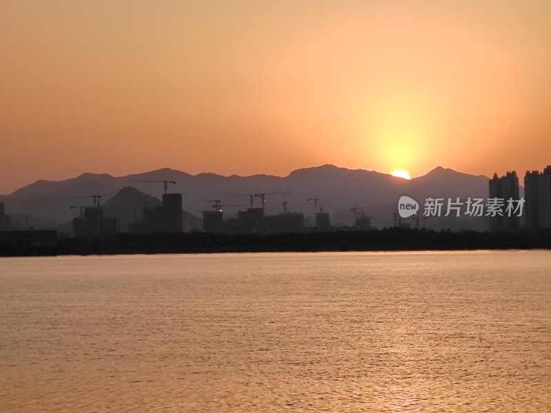 山水间的落日余晖映照城市建筑