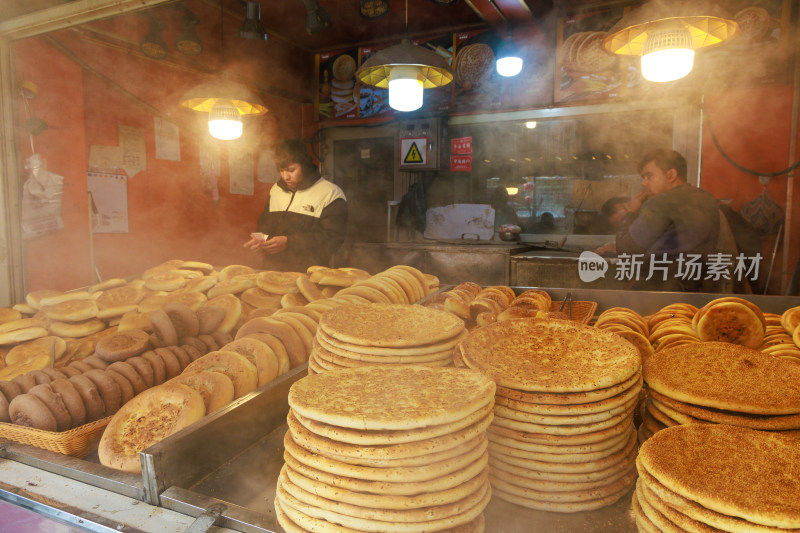 新疆乌鲁木齐店内工人制作传统面饼馕的场景