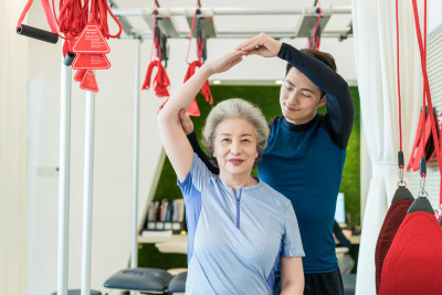 老年女子在私教的指导下健身