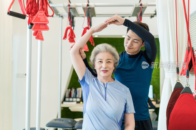 老年女子在私教的指导下健身