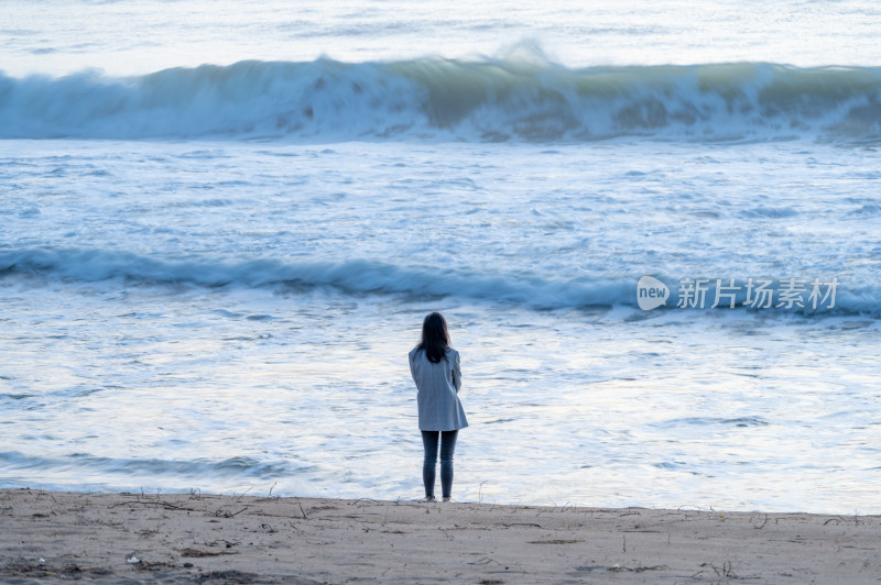 海南三亚海棠湾亚洲美女海边沙滩日出的背影