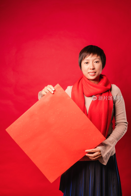 红色背景前拿空白门贴纸的中国女性