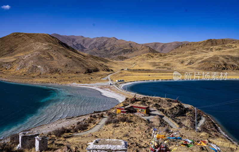 藏区湖泊旁的多彩建筑与周边山峦景色