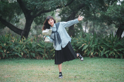 捧着鲜花在公园里微笑的美丽女人写真