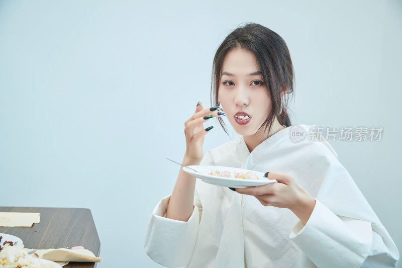 在烘焙店吃蛋糕喝饮料的可爱亚洲少女