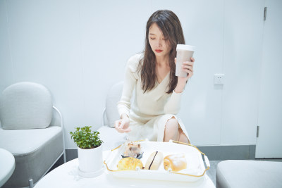 在烘焙店吃面包喝牛奶的可爱亚洲少女