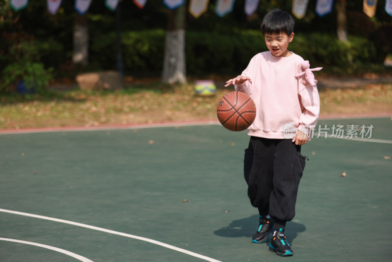 亚洲男孩在篮球场打篮球