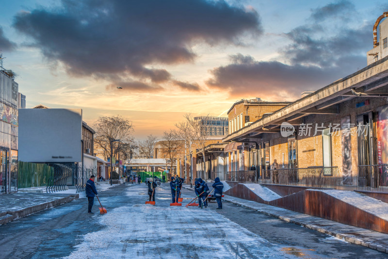 傍晚夕阳冬季扫雪工人清洁路面积雪