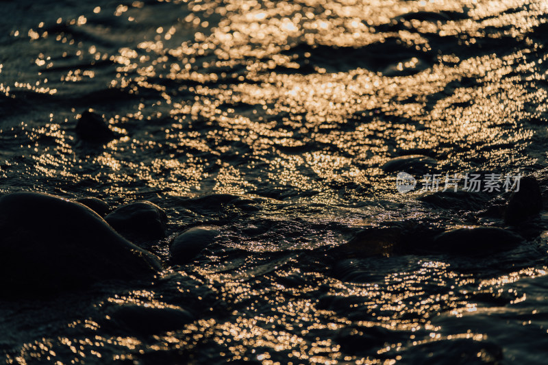日落时阳光洒在波光粼粼的水面上