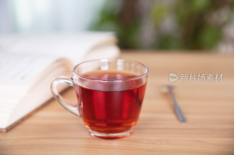 一杯红茶和一本书及旁边的勺子