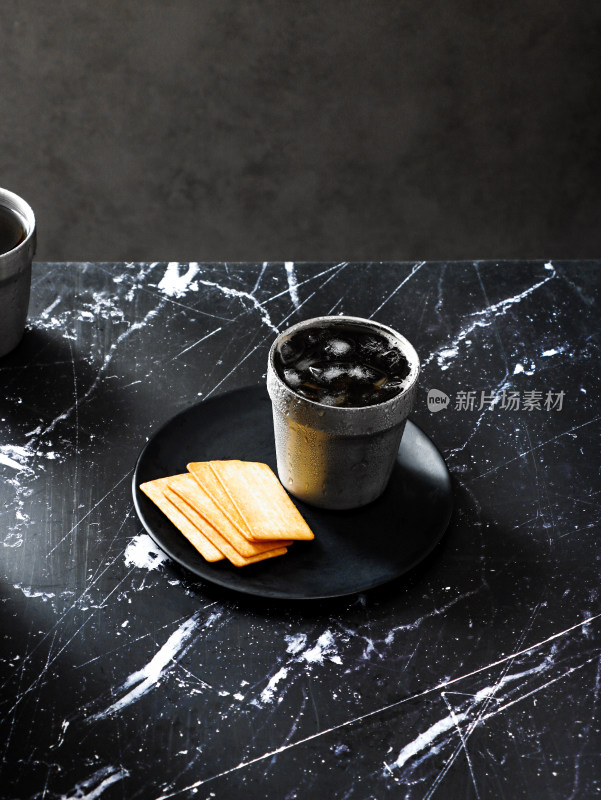 黑色花岗岩桌面上摆放着饼干和饮品咖啡
