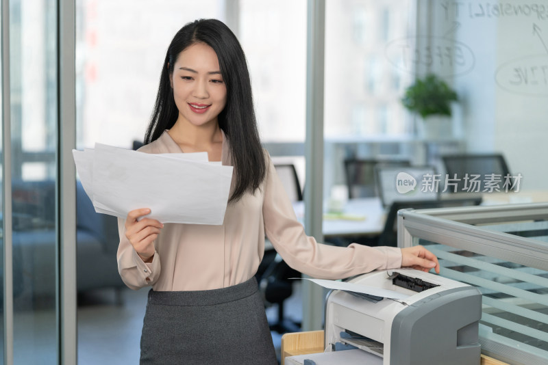 年轻商务女士使用打印机