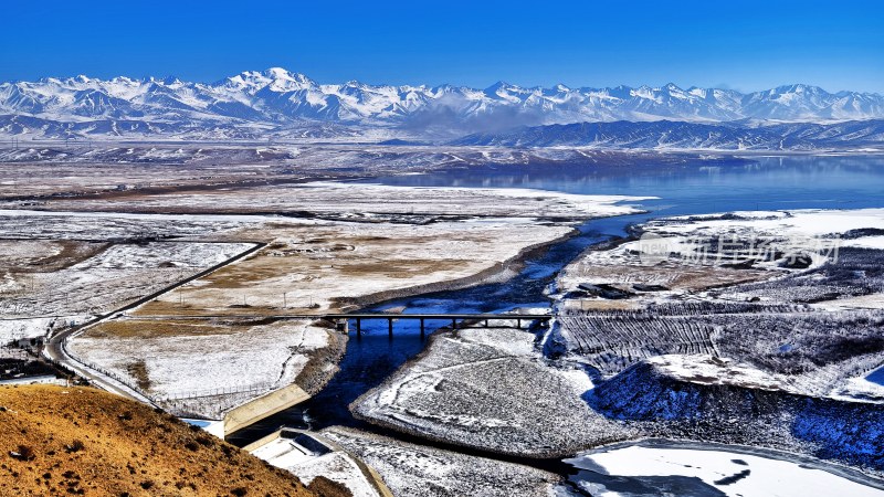 雪山下的桥梁与湖泊的广阔自然景观