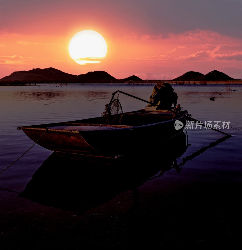 湖面小船夕阳下剪影景象