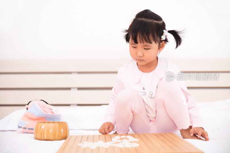 可爱的小女孩在玩围棋