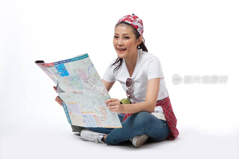 棚拍户外旅行的年轻女人坐在地上看地图