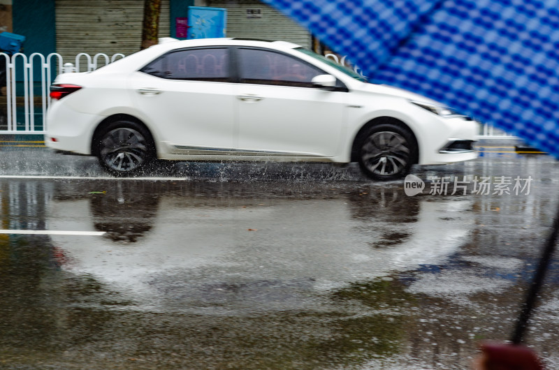 雨天极速驶过的一辆白色汽车