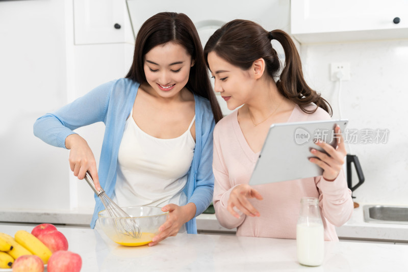 年轻女子在厨房边做饭边和朋友聊天