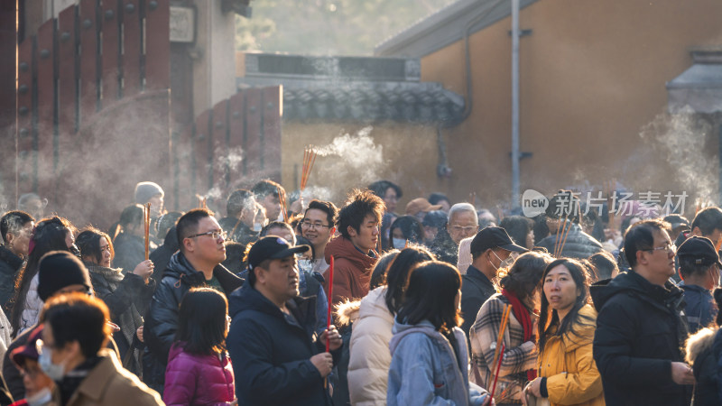 寺庙外众多香客手持香祈福